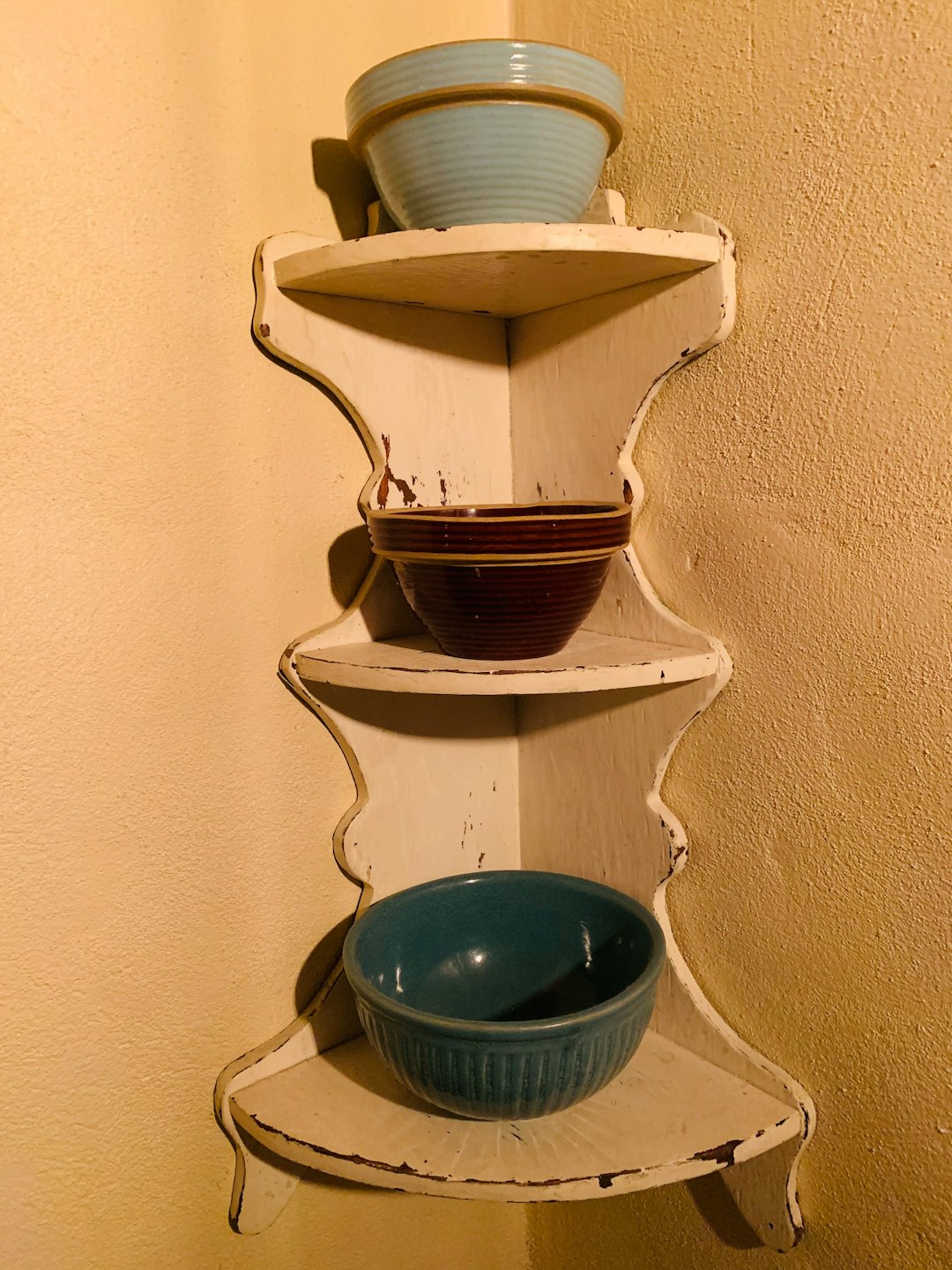 Styled small kitchen corner with walnut shelves, ceramics, and warm afternoon light