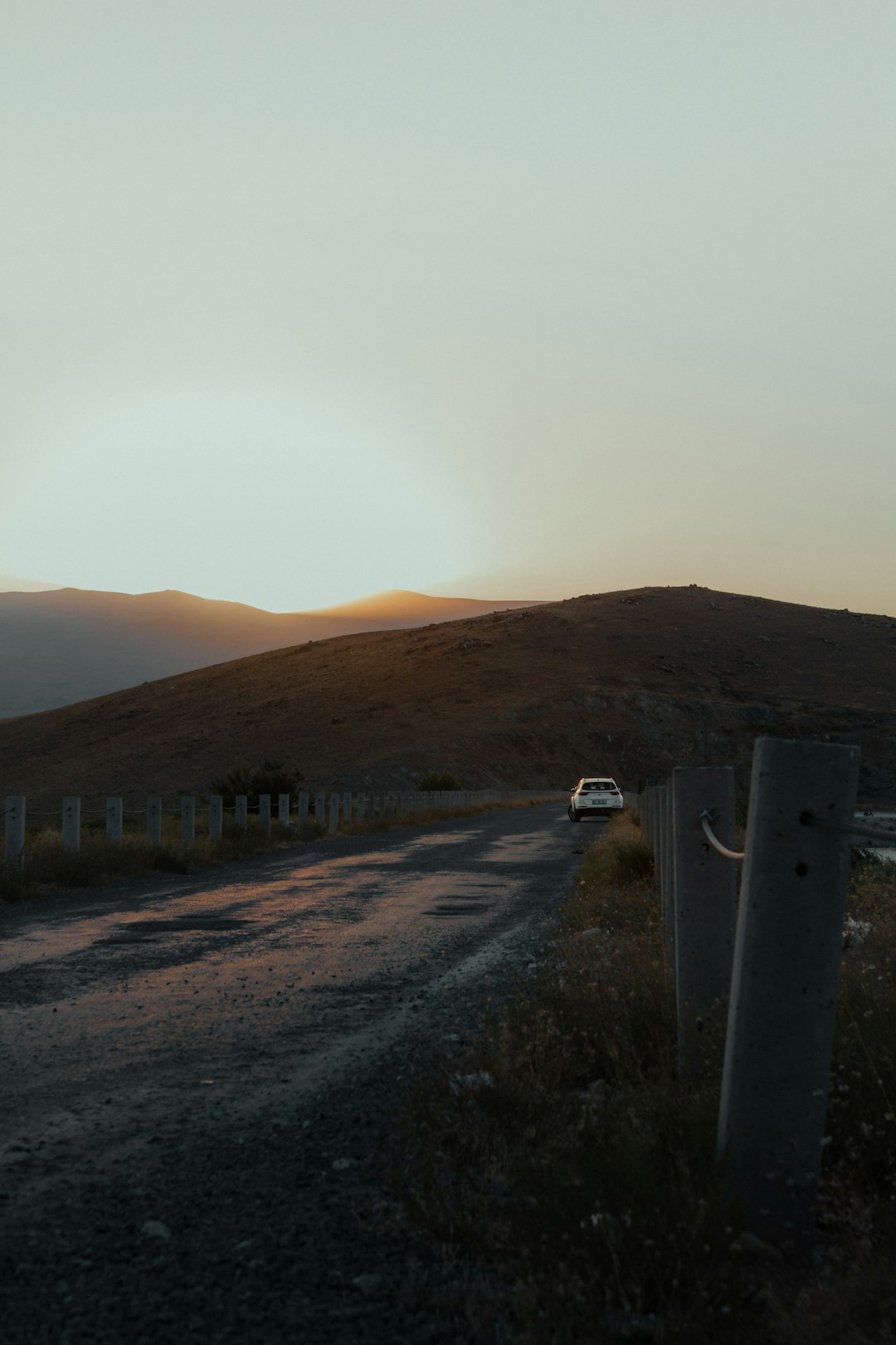 Elektrofahrzeug auf Bergstraße bei Sonnenaufgang