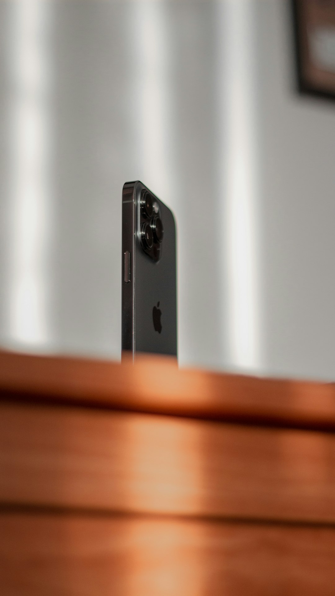 Single smartphone standing upright on a wooden surface