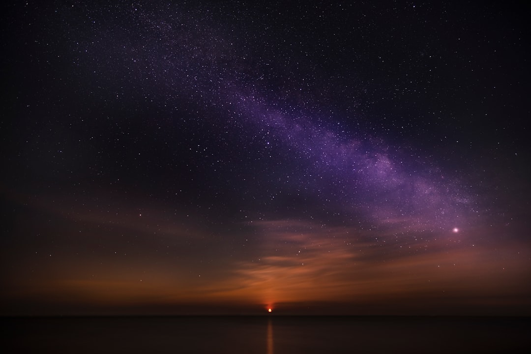 Titan's methane lake at twilight with Saturn above