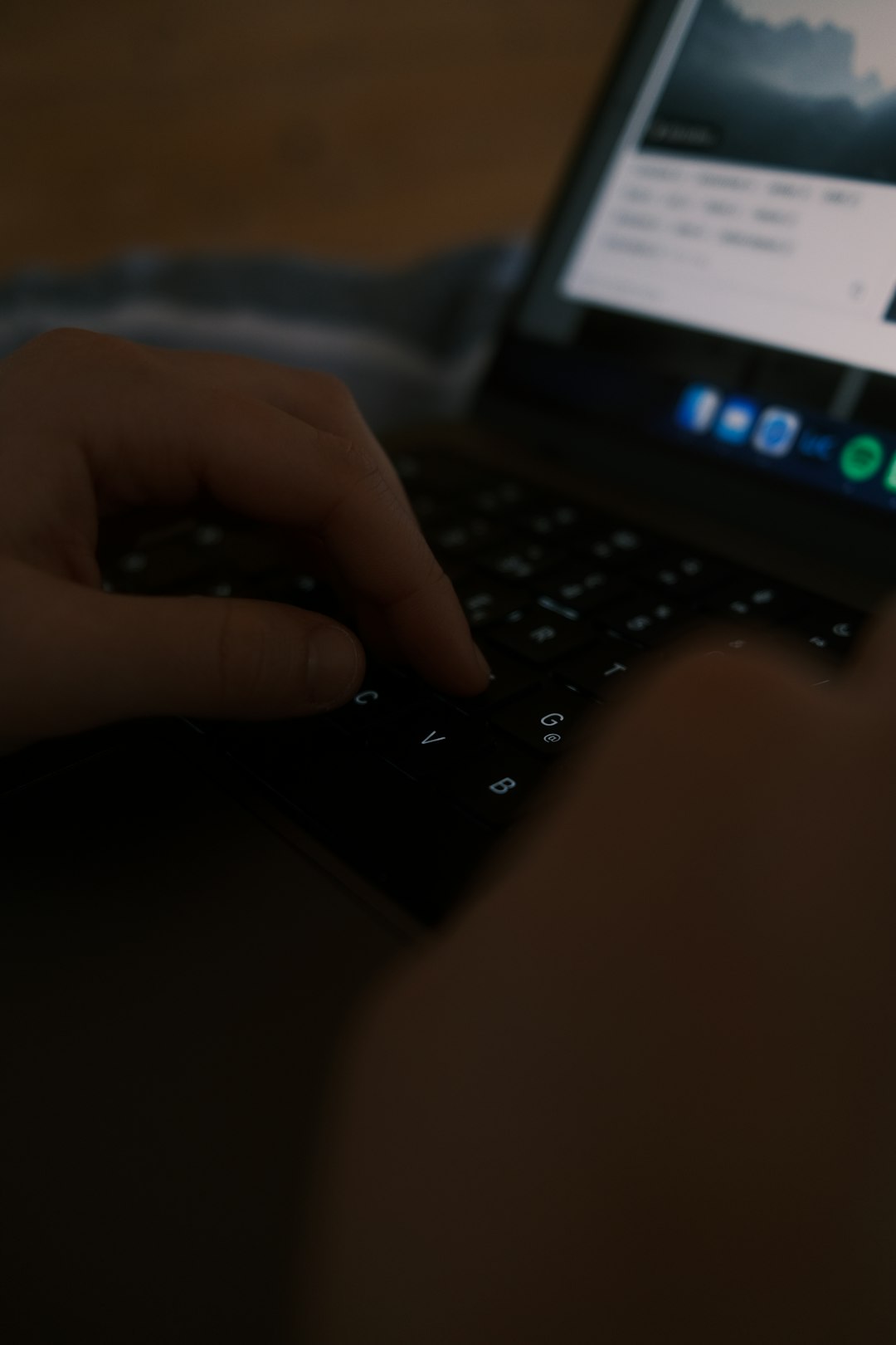 Hands typing on laptop with VPN active in cafe