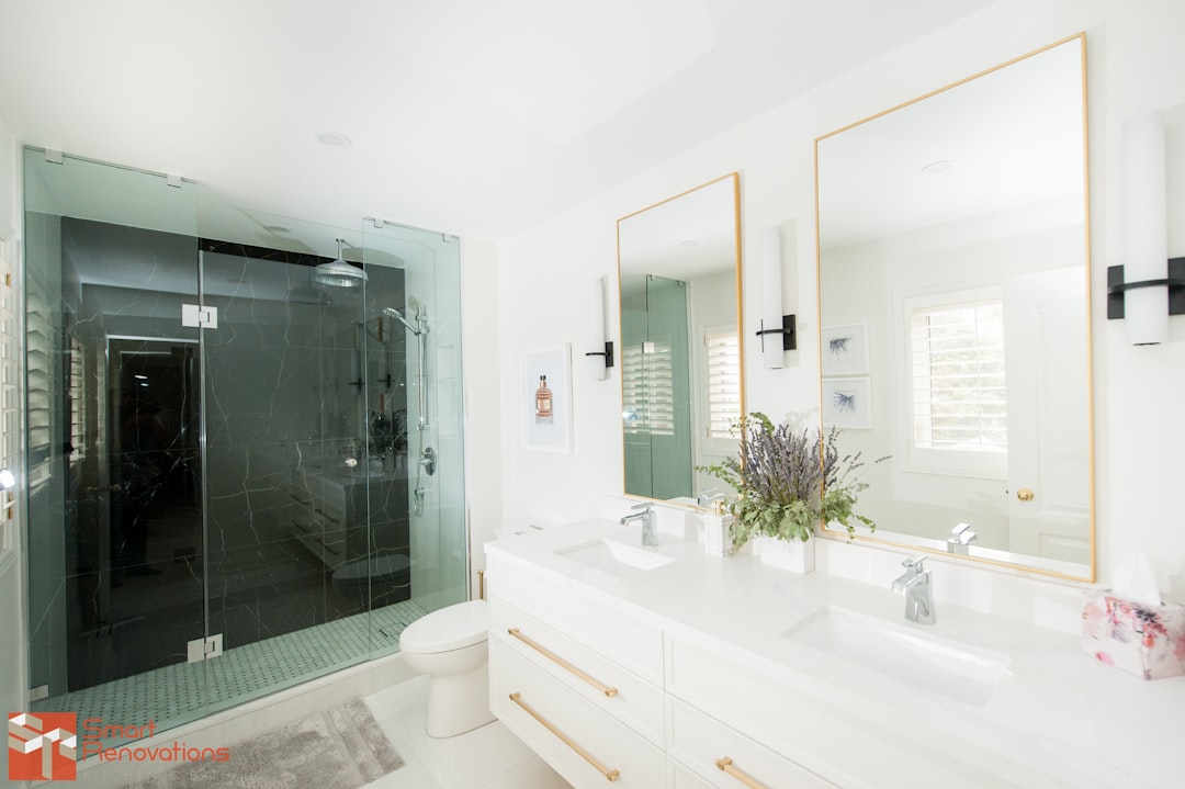 Small bathroom with frameless glass walk-in shower and marble tile