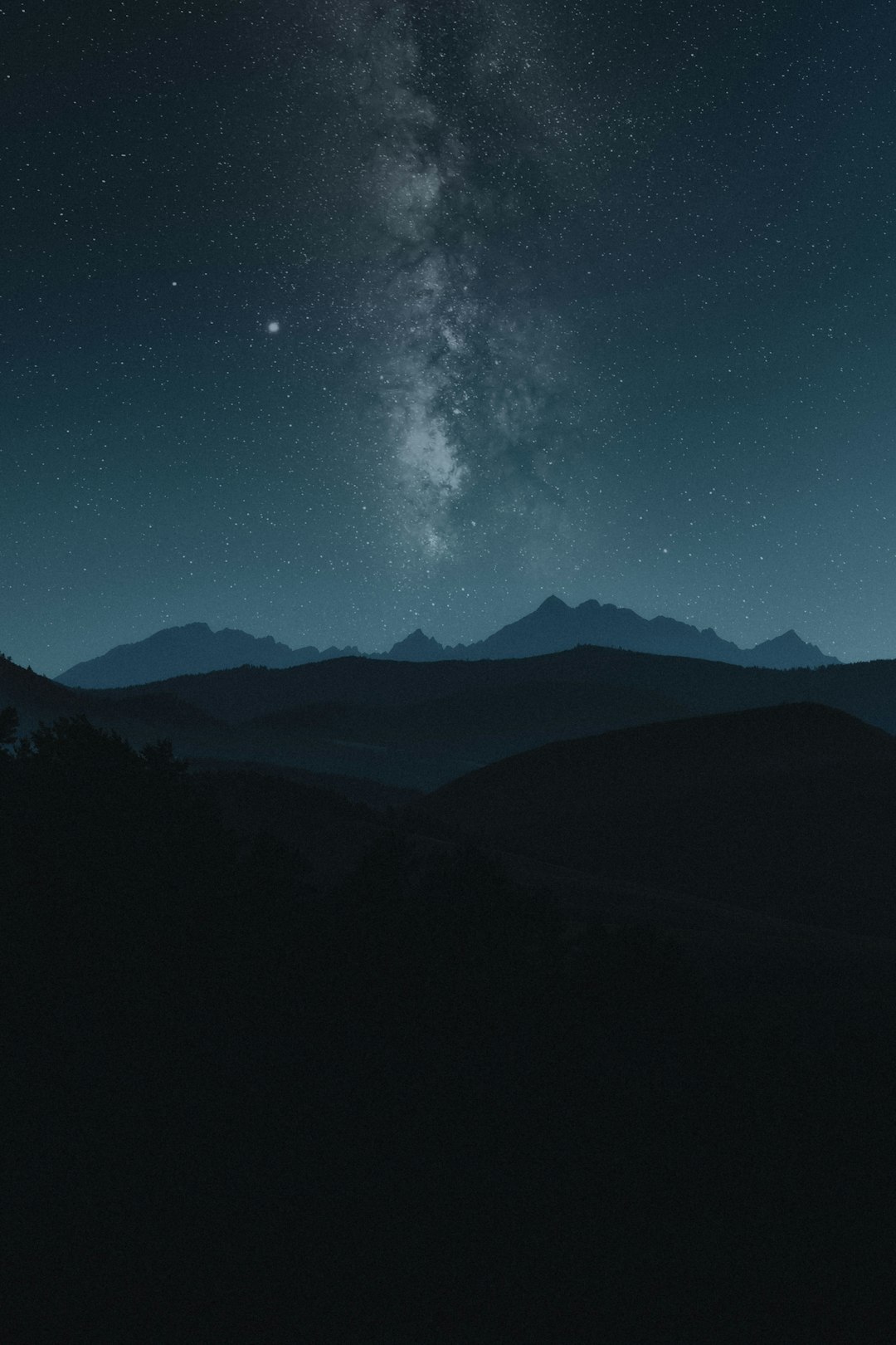Milky Way night sky with distant galaxy on horizon