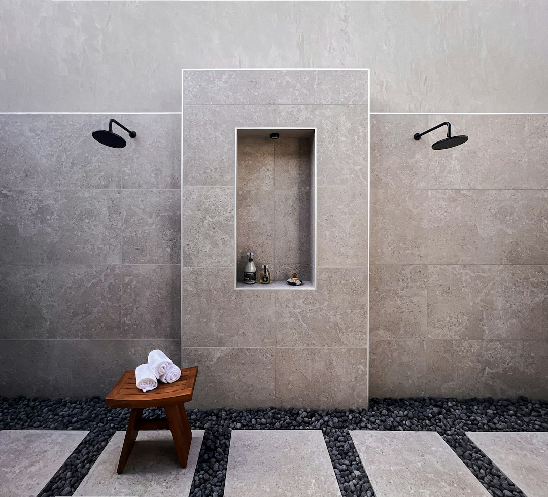 Limestone wall tiles with stone floor and limewash plaster in Japandi bathroom
